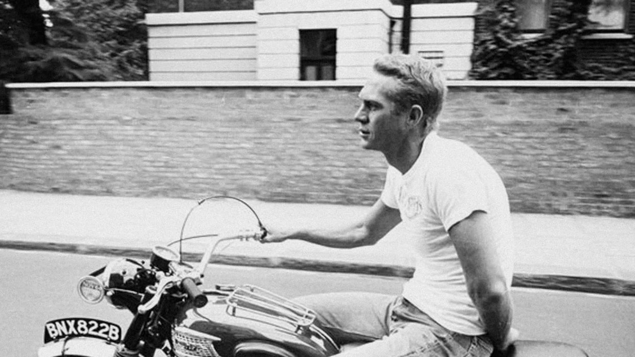Steve McQueen on a motorcycle in a white t-shirt — defining mid-century rebel style