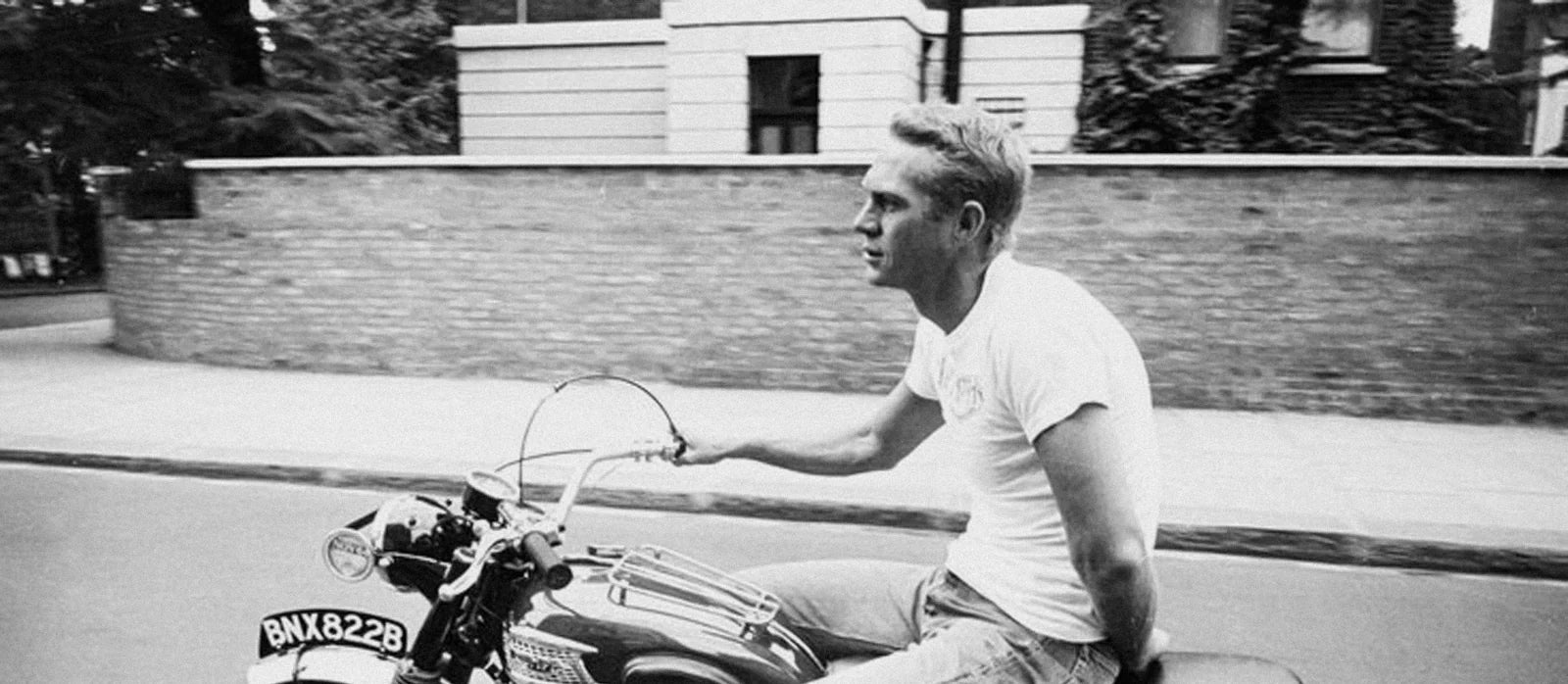 Steve McQueen on a motorcycle in a white t-shirt — defining mid-century rebel style